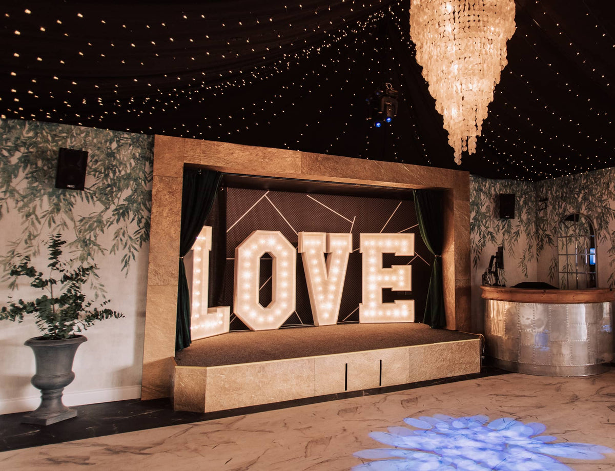 Gold metal veneer event stage surround with illuminated LOVE letters