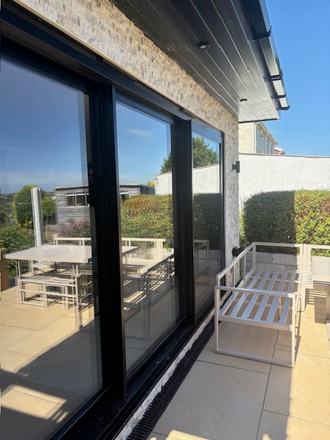 Split face stone cladding on exterior house facade above patio doors