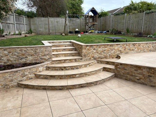 Split face stone cladding on garden retaining walls and patio steps