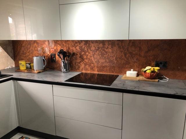 Copper metal veneer kitchen splashback with dark worktop