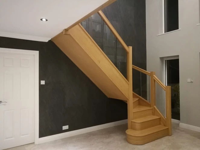 D Black slate veneer feature wall beneath wooden staircase