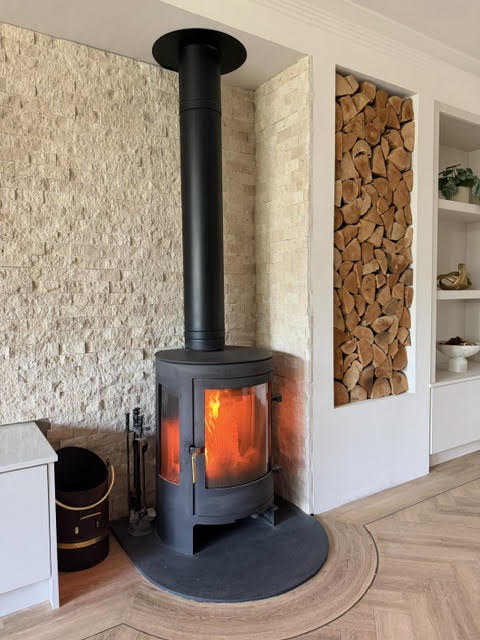 Classic travertine split face cladding behind a log burner.