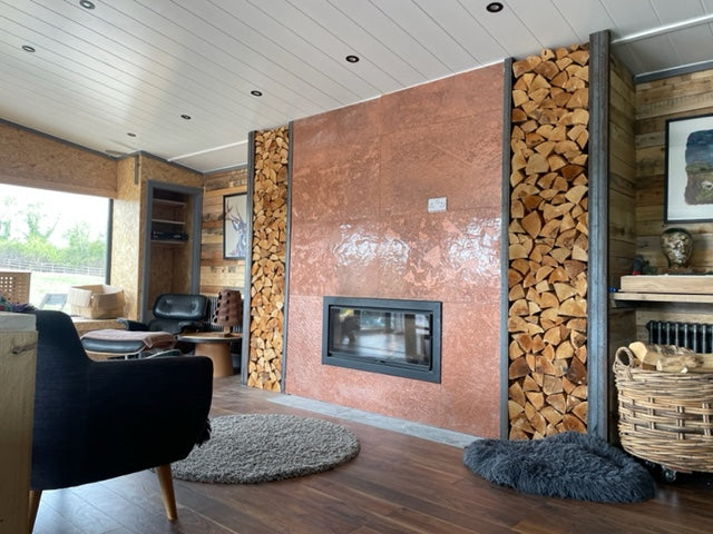 Copper metal veneer fireplace feature wall with log storage