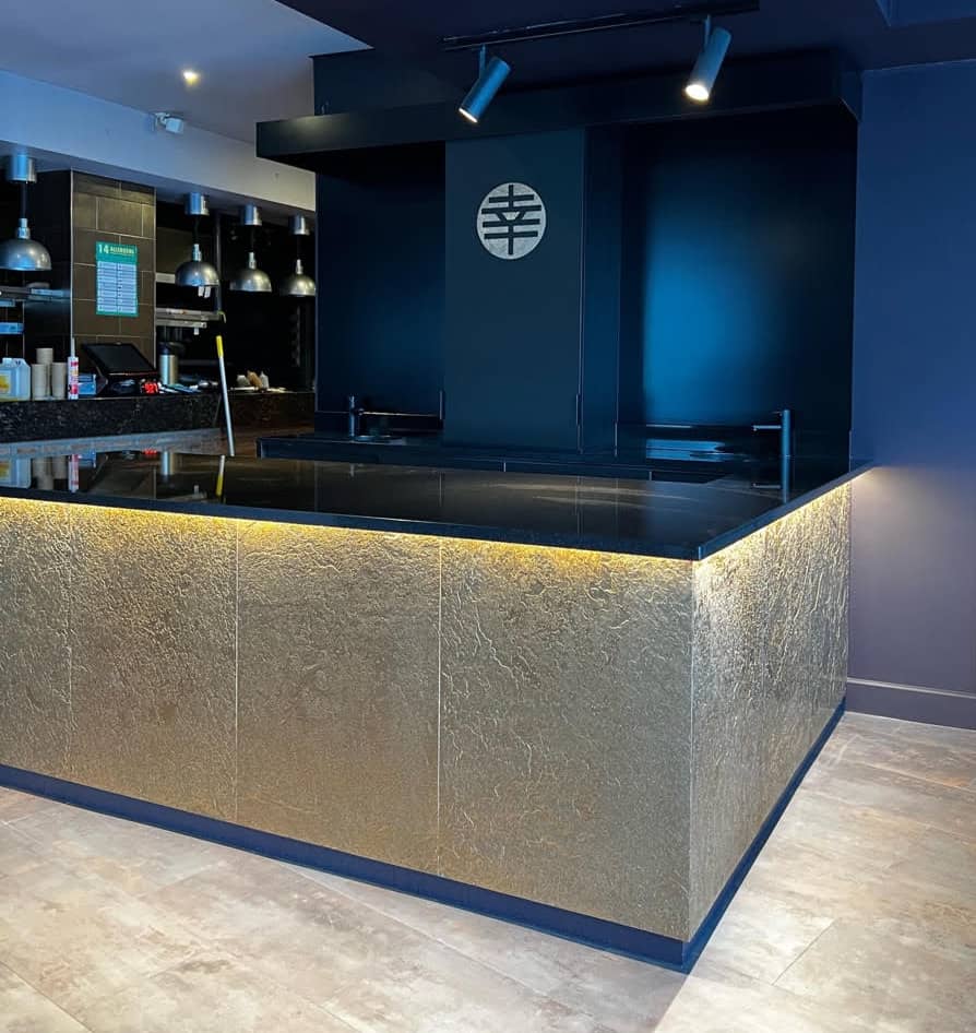 Gold metal veneer bar counter with illuminated textured panels