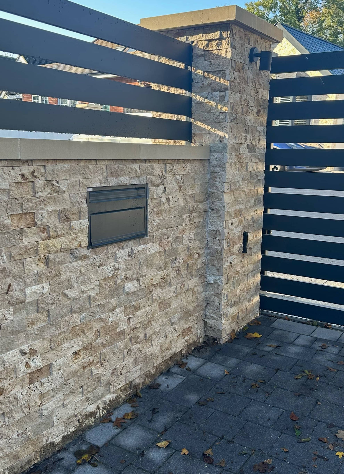 Rustic travertine split face cladding on exterior garden wall