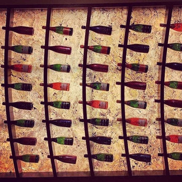 Back-lit translucent stone veneer wine display wall.