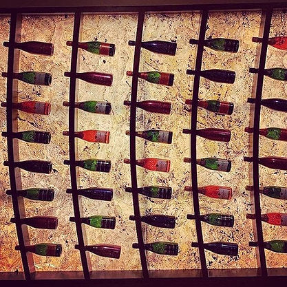 Backlit Falling Leaves translucent stone veneer wine rack feature wall.